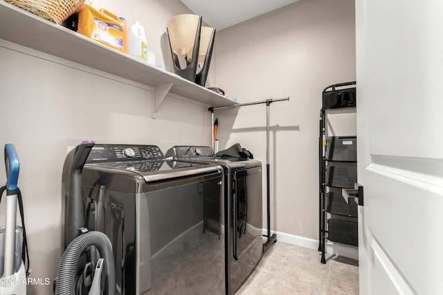 clothes washing area featuring laundry area, washing machine and dryer, and baseboards