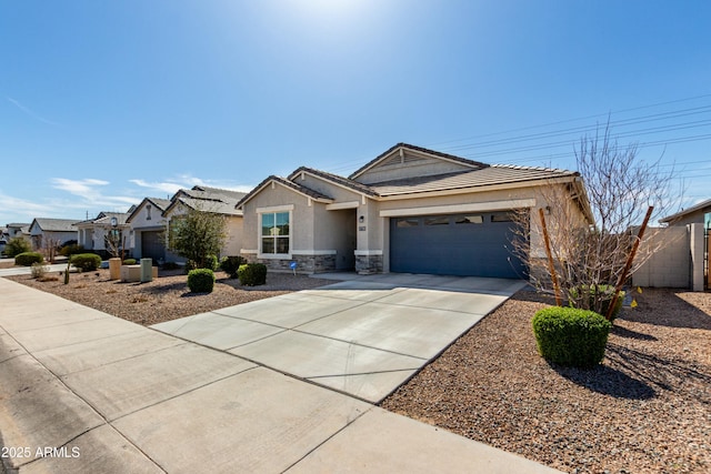 view of front of home with fence, stucco siding, concrete driveway, a garage, and stone siding