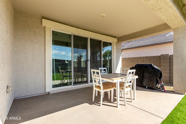 view of patio featuring area for grilling, outdoor dining space, and fence