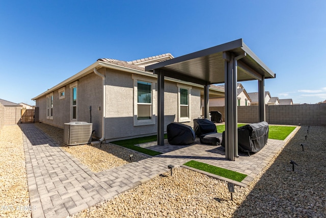 view of side of home with central air condition unit, a patio area, a fenced backyard, and stucco siding