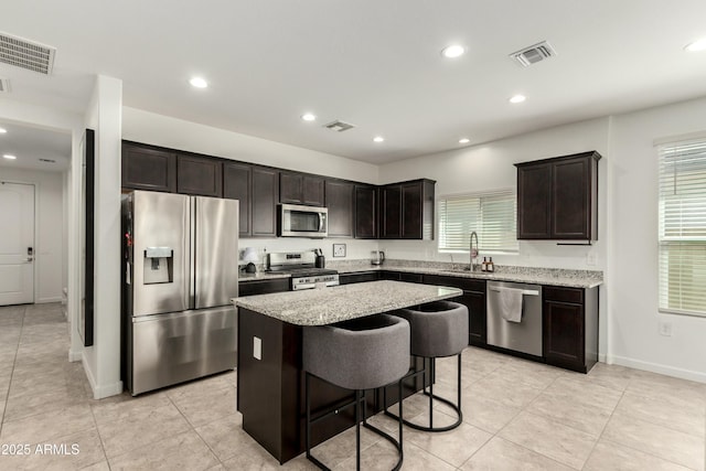 kitchen featuring a sink, stainless steel appliances, a kitchen island, and visible vents