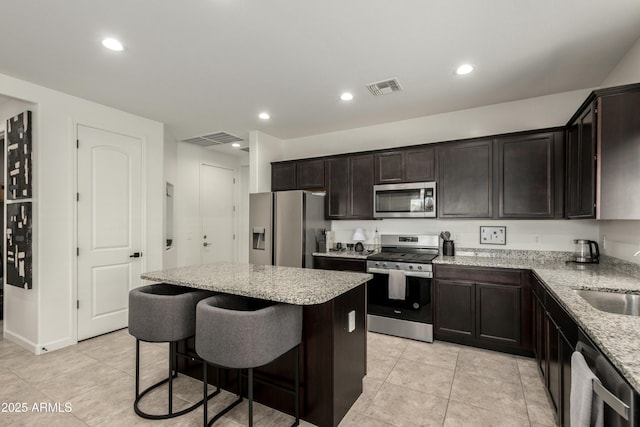 kitchen featuring a center island, visible vents, stainless steel appliances, and a sink