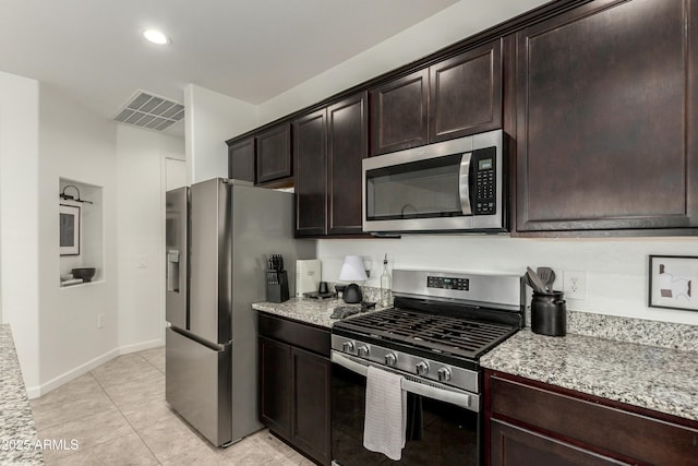 kitchen with visible vents, light stone counters, appliances with stainless steel finishes, baseboards, and dark brown cabinets