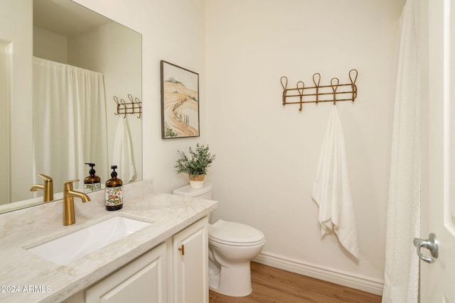 bathroom with toilet, wood-type flooring, and vanity