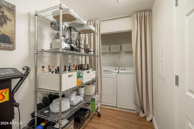 laundry room with light hardwood / wood-style floors and washer and clothes dryer