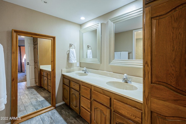 bathroom with double vanity, wood finished floors, and a sink