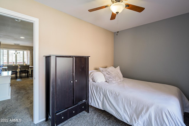 bedroom with ceiling fan and dark colored carpet