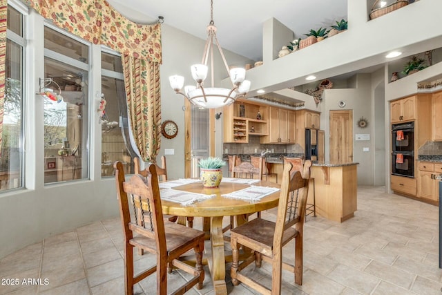 dining room featuring a towering ceiling and an inviting chandelier