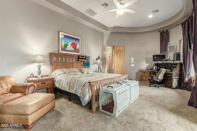 carpeted bedroom featuring a raised ceiling, visible vents, and ceiling fan