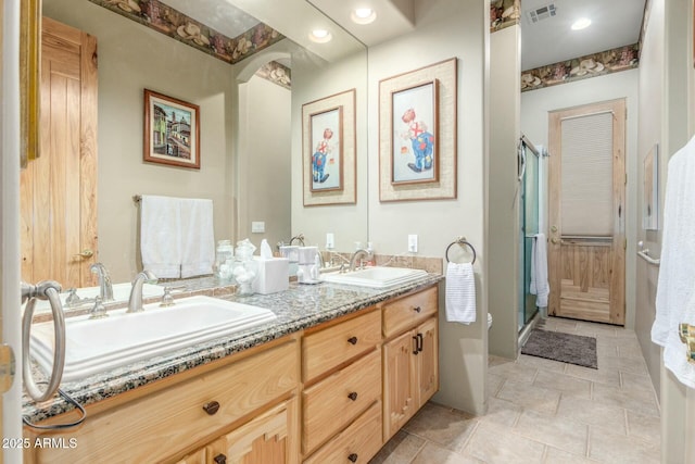 bathroom with visible vents, a sink, a shower stall, and double vanity