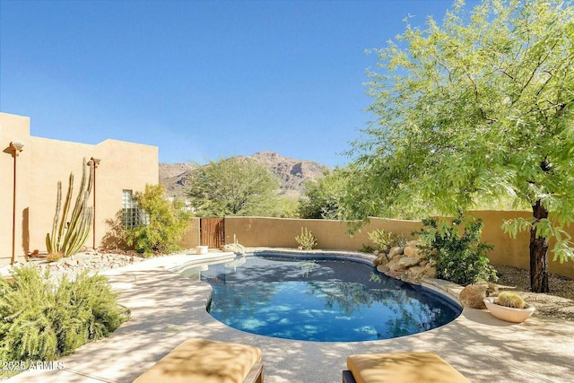 view of swimming pool featuring a fenced backyard, a mountain view, a fenced in pool, and a patio