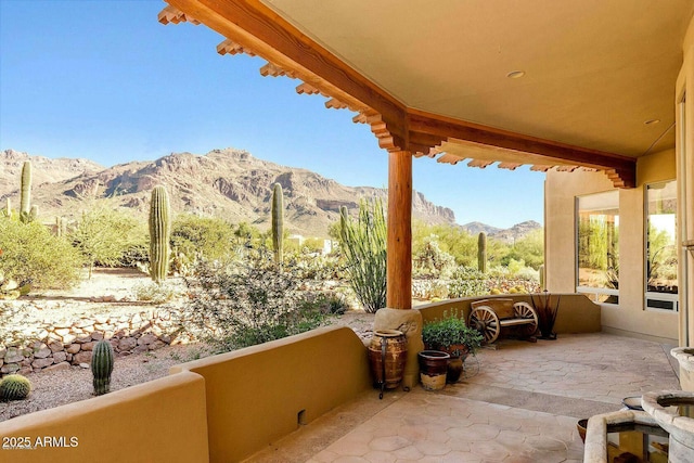 view of patio featuring a mountain view and a balcony