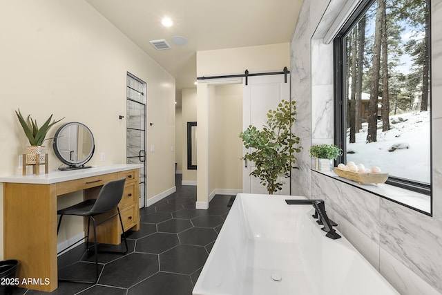 bathroom featuring tile patterned floors, a bath, and vanity