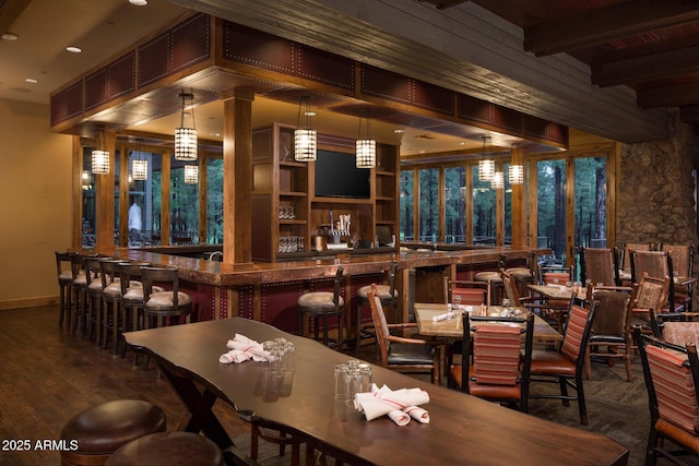 bar with beamed ceiling, decorative light fixtures, and hardwood / wood-style flooring