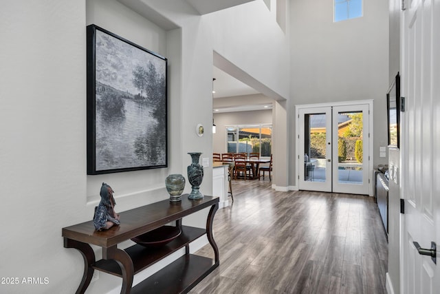 interior space with hardwood / wood-style flooring, a high ceiling, and french doors