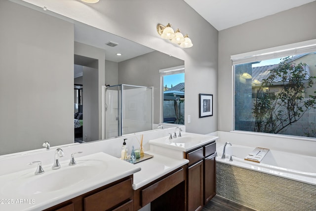 bathroom with vanity, shower with separate bathtub, and hardwood / wood-style floors