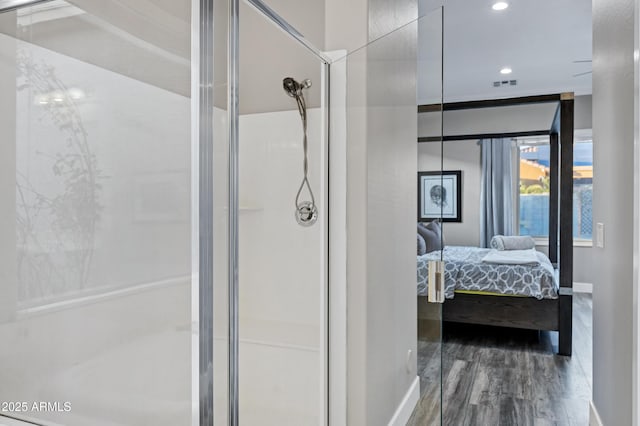 bathroom with wood-type flooring and a shower with shower door