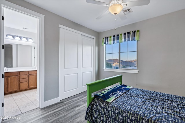 bedroom with ceiling fan, connected bathroom, a closet, and light hardwood / wood-style flooring