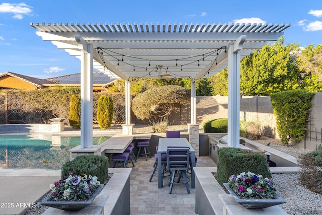 view of patio with a fenced in pool, an outdoor kitchen, and a pergola