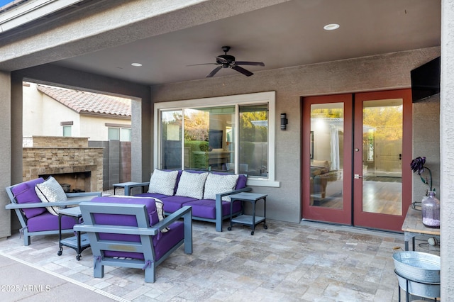 view of patio / terrace with french doors, ceiling fan, and an outdoor living space with a fireplace