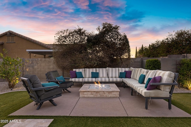 patio terrace at dusk with an outdoor living space with a fire pit