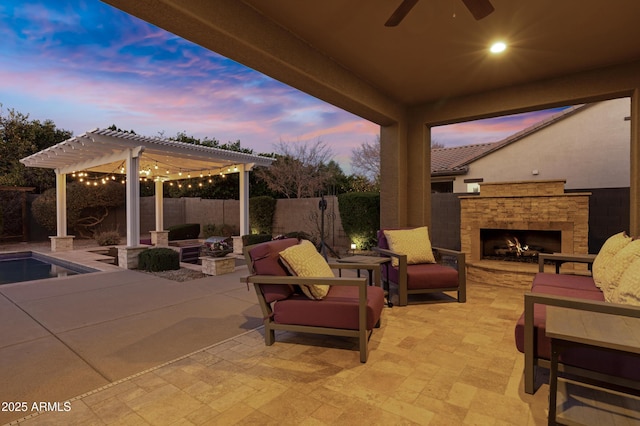 patio terrace at dusk with an outdoor living space with a fireplace and a pergola