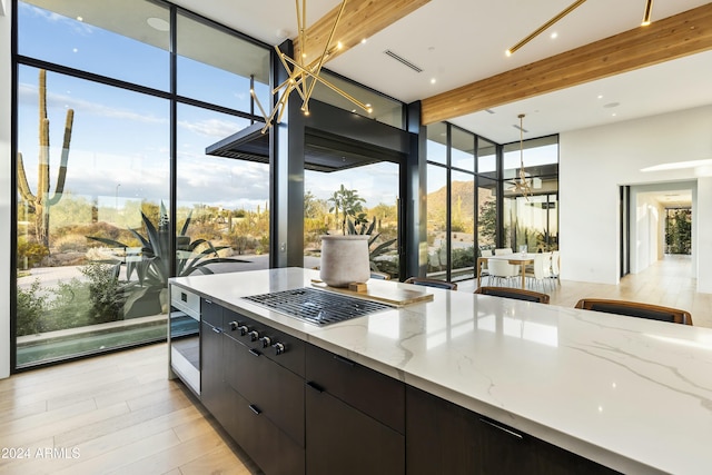 kitchen with visible vents, light wood-style flooring, modern cabinets, hanging light fixtures, and a wall of windows