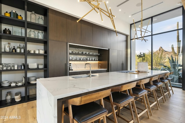 kitchen featuring light stone countertops, modern cabinets, open shelves, and light wood-style floors