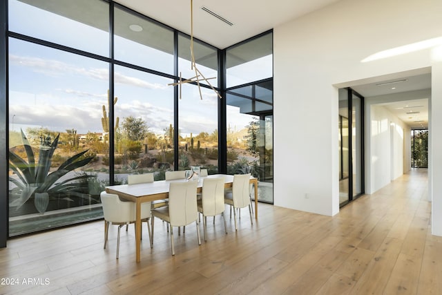 dining room featuring visible vents, floor to ceiling windows, and wood finished floors