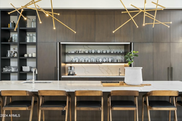 bar featuring a chandelier, indoor wet bar, and a sink