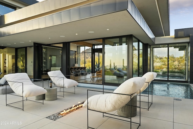 patio terrace at dusk featuring an outdoor pool