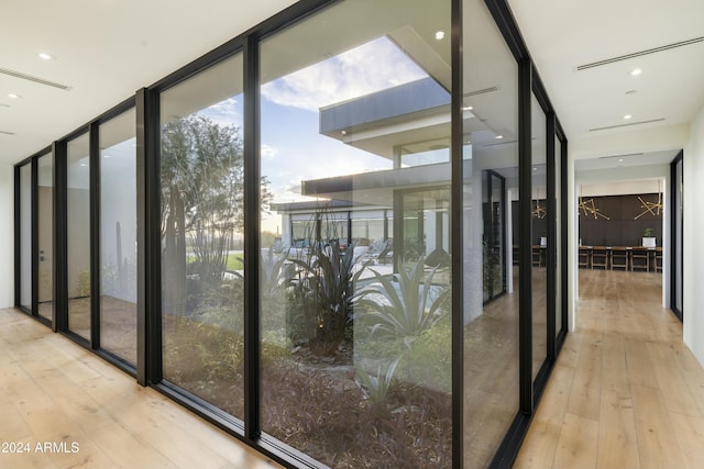 corridor featuring expansive windows and light wood-style flooring