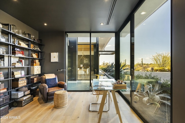 interior space with a wall of windows and wood finished floors