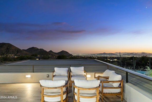 balcony at dusk featuring a mountain view