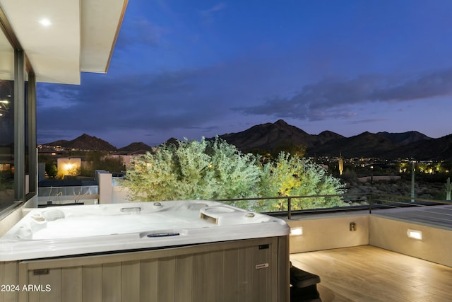 patio terrace at dusk with a mountain view and a hot tub