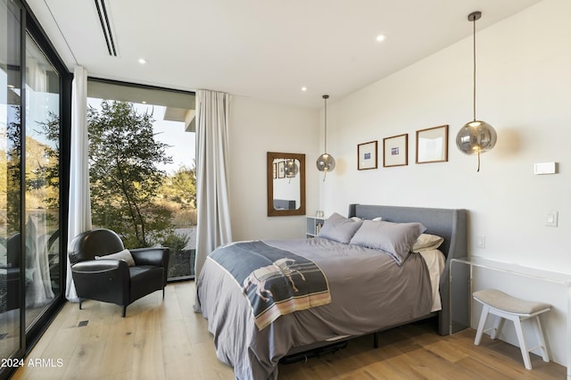 bedroom with light wood-style floors, recessed lighting, and floor to ceiling windows