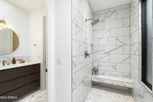 full bathroom featuring a tile shower and vanity