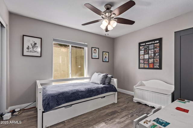 bedroom with wood finished floors, a ceiling fan, and baseboards