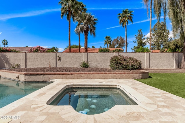 view of swimming pool featuring a fenced backyard, a fenced in pool, and an in ground hot tub