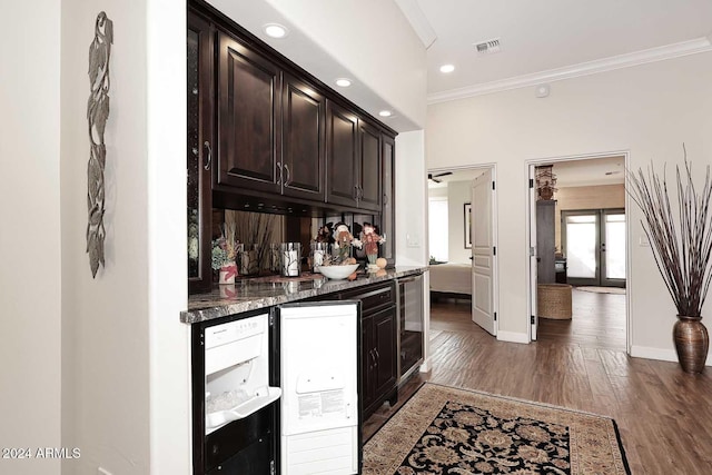 bar featuring dark stone counters, dark brown cabinetry, dark wood-type flooring, crown molding, and wine cooler