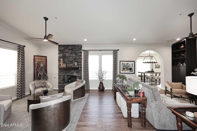 living room with ceiling fan, dark hardwood / wood-style flooring, a fireplace, and crown molding