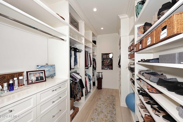 walk in closet with light hardwood / wood-style floors