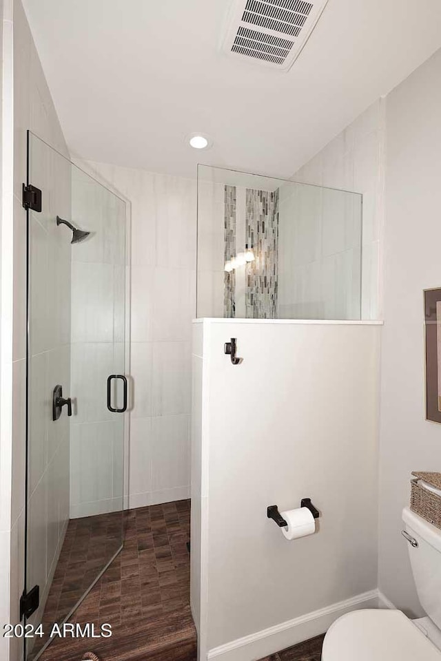 bathroom with an enclosed shower and toilet