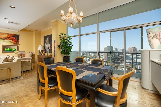 dining area featuring visible vents, a wall of windows, ornamental molding, a notable chandelier, and a view of city