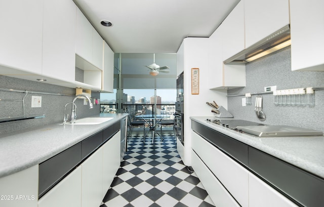 kitchen with tile patterned floors, white cabinetry, a sink, and light countertops