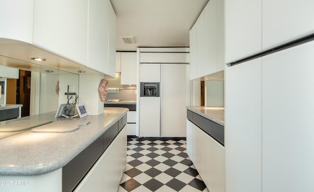 kitchen featuring light floors, paneled built in refrigerator, light countertops, white cabinets, and modern cabinets