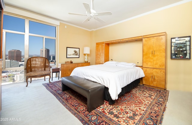 bedroom featuring a view of city, a ceiling fan, carpet floors, and ornamental molding