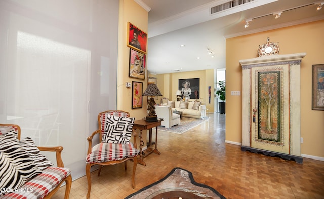 interior space featuring crown molding, rail lighting, baseboards, and visible vents