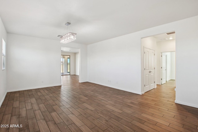 spare room with an inviting chandelier