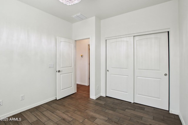 unfurnished bedroom featuring dark wood-type flooring and a closet